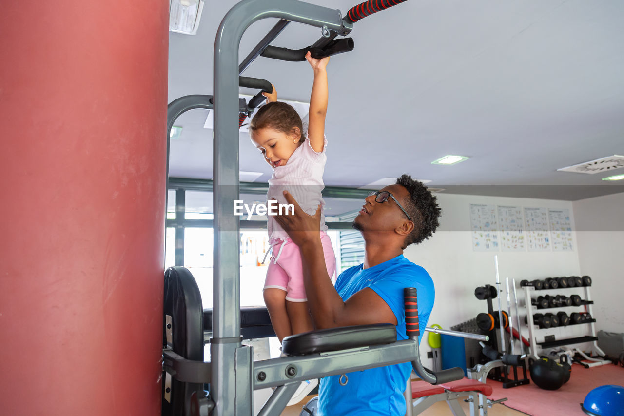 Dad teaching daughter to do pull ups