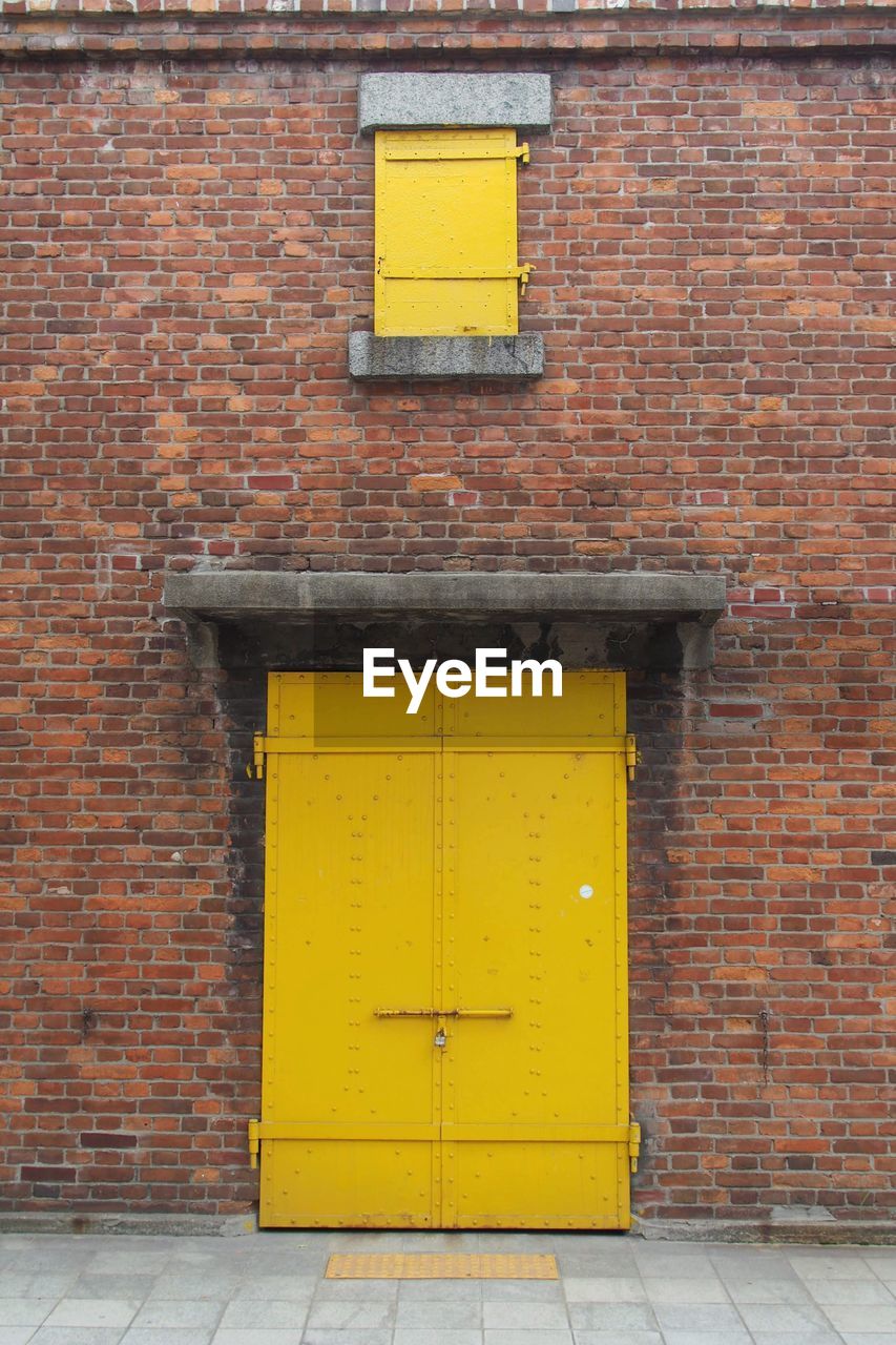 Yellow door on brick wall of building