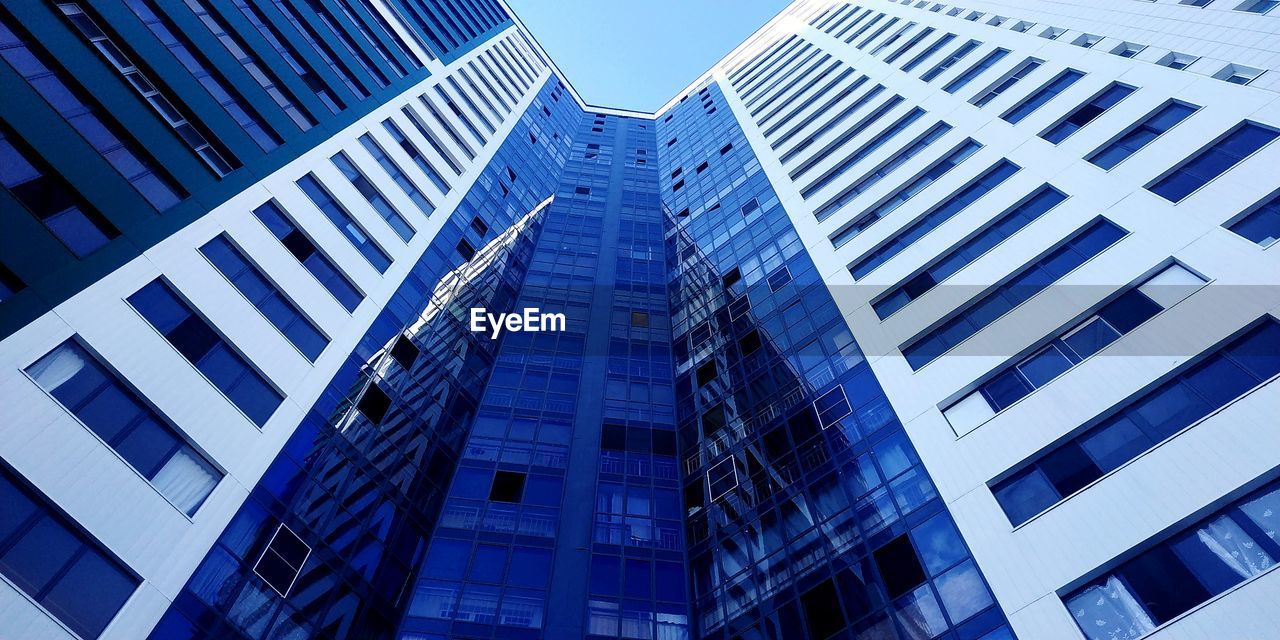 Low angle view of modern buildings against clear blue sky