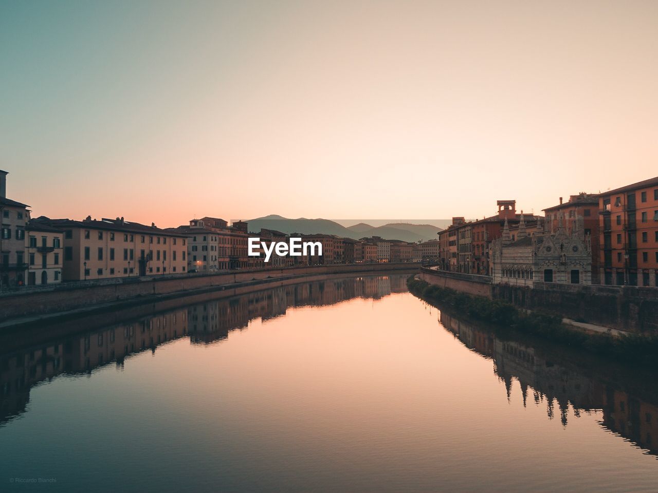 Reflection of buildings in city at sunset