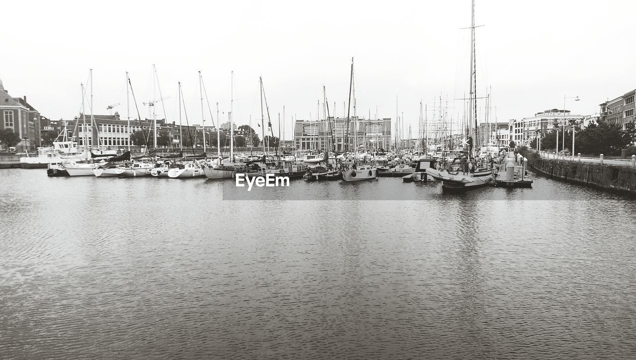 View of boats moored at harbor against clear sky