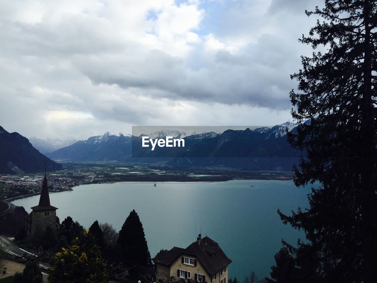 Lake and mountains against cloudy sky