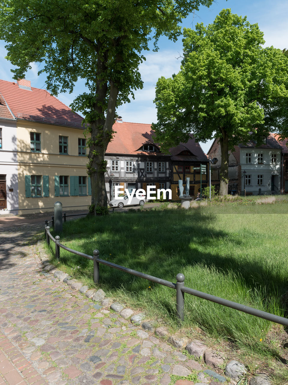 HOUSES BY BUILDINGS AGAINST SKY