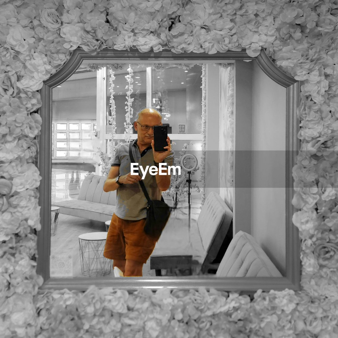 white, adult, wall, one person, indoors, standing, holding, technology, architecture, window, clothing, men, full length, young adult, person, casual clothing, lifestyles, wireless technology, occupation, built structure, communication, hat, activity, house, looking, wall - building feature