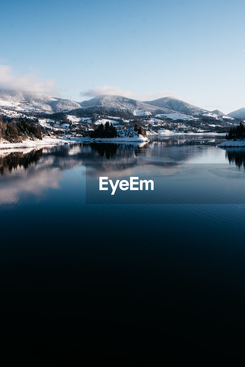 Scenic view of lake and snowcapped mountains against sky during winter