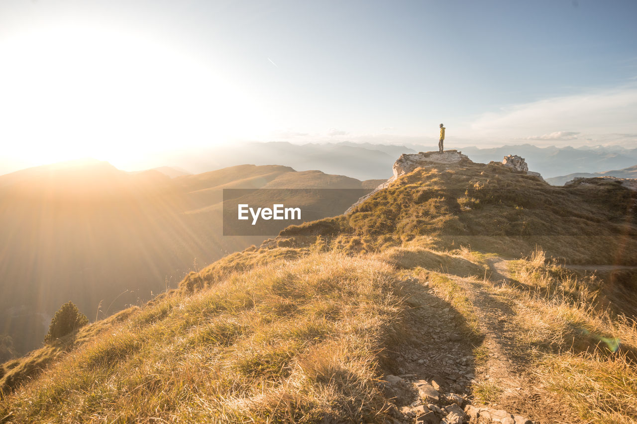 Man standing on cliff against sky