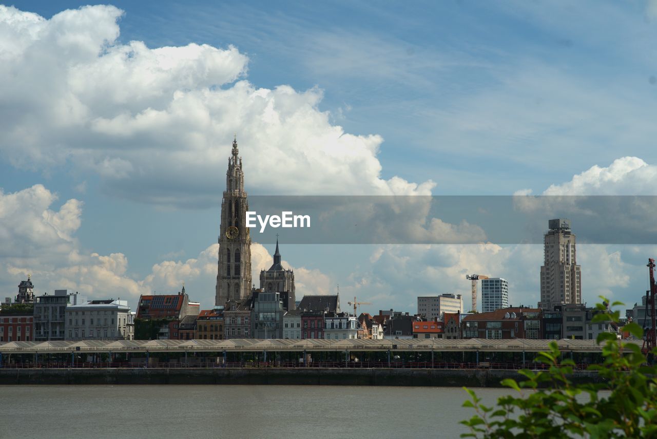 buildings in city against cloudy sky