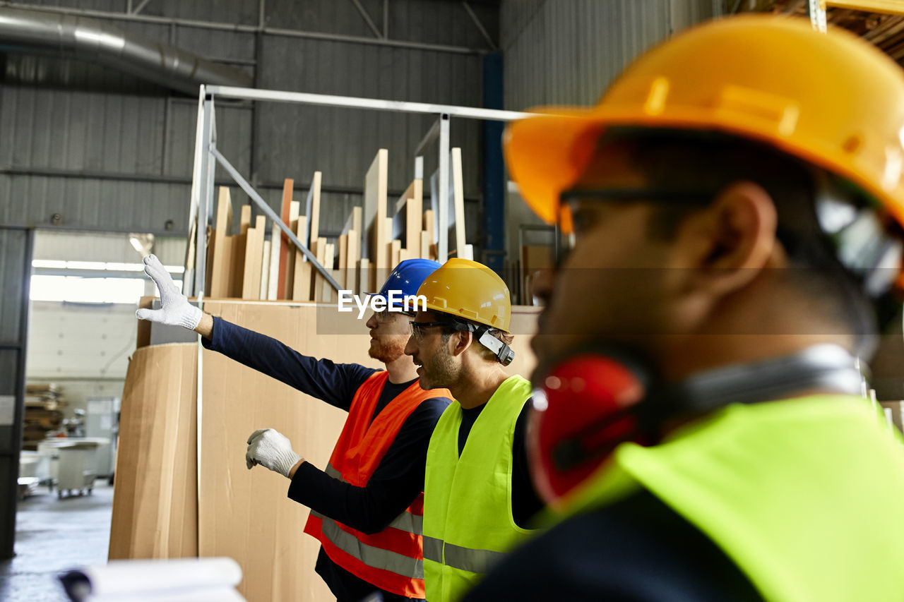 Workers talking in factory workshop