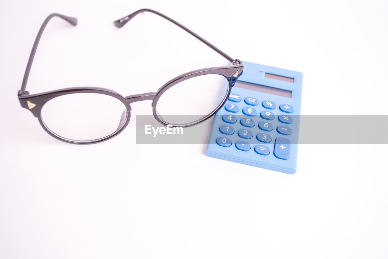 HIGH ANGLE VIEW OF EYEGLASSES ON WHITE TABLE