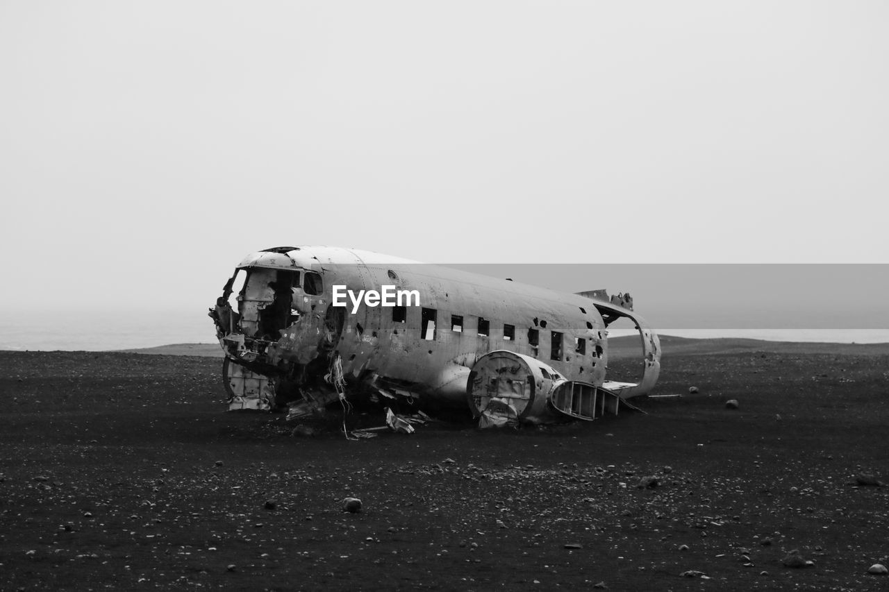 Damaged airplane on field against sky