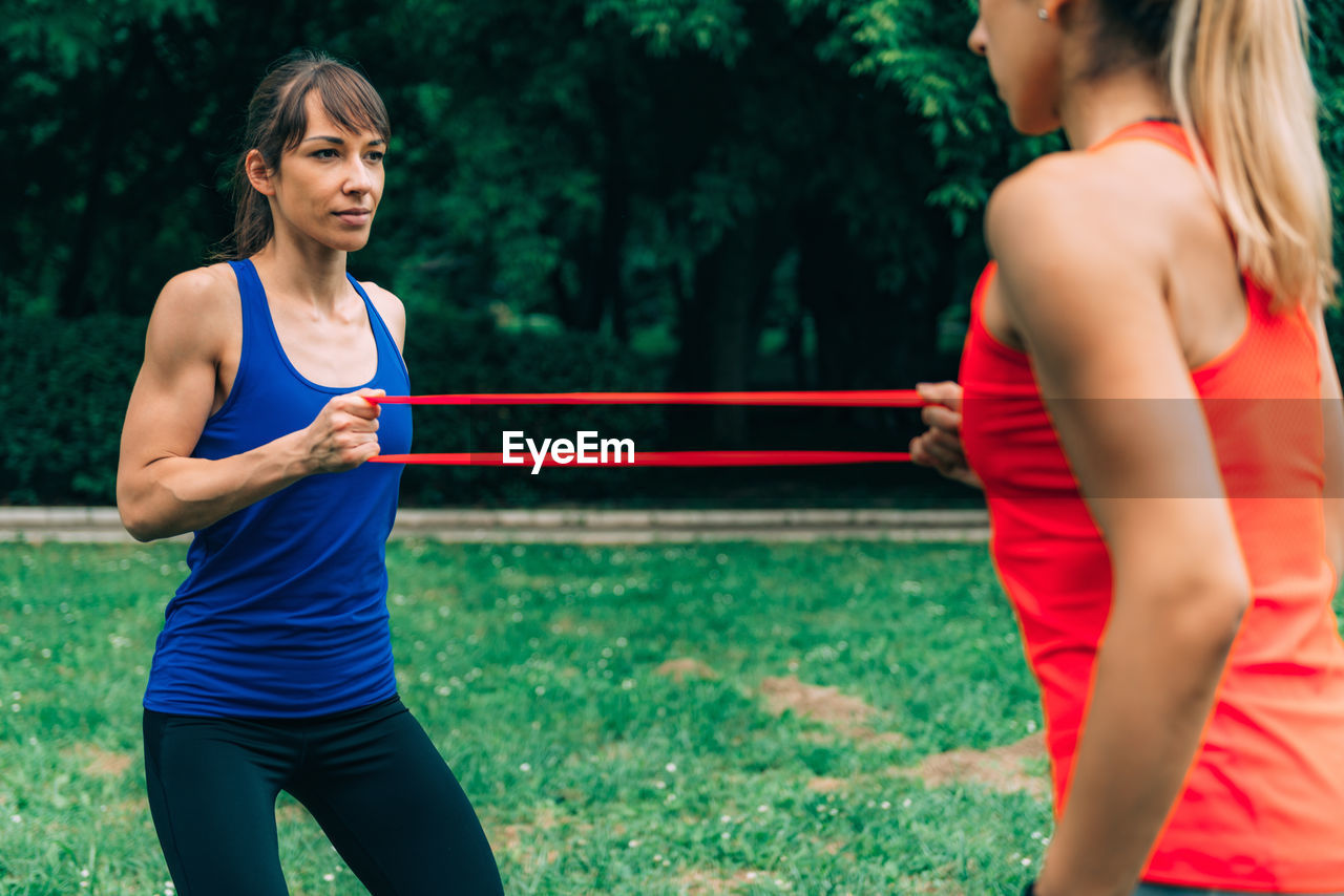 Female athletes exercising with resistance bands at park