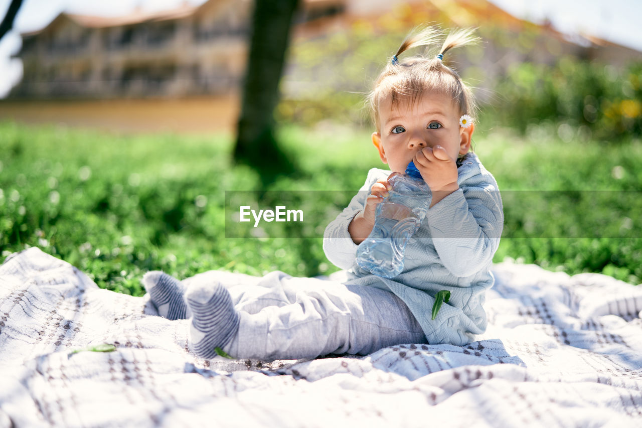 Portrait of cute girl sitting on grass