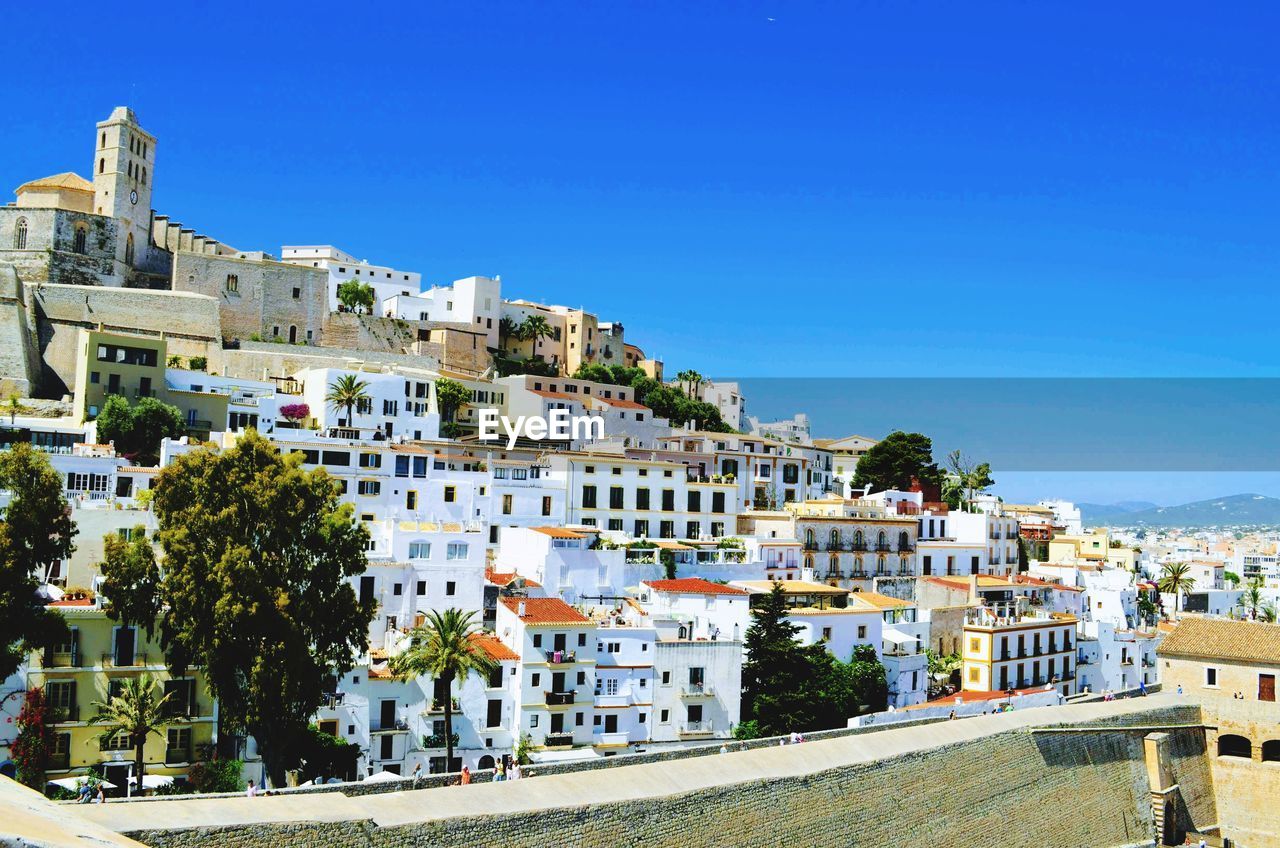 Buildings in old town ibiza against clear blue sky