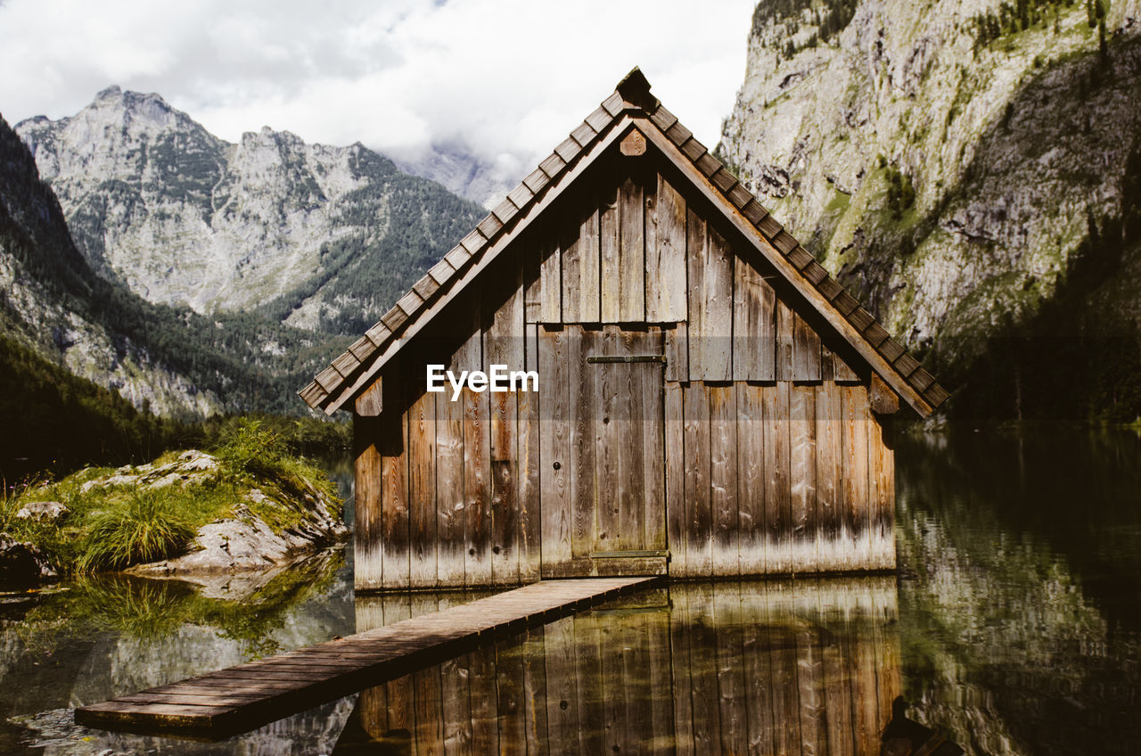 Log cabin in lake against mountains