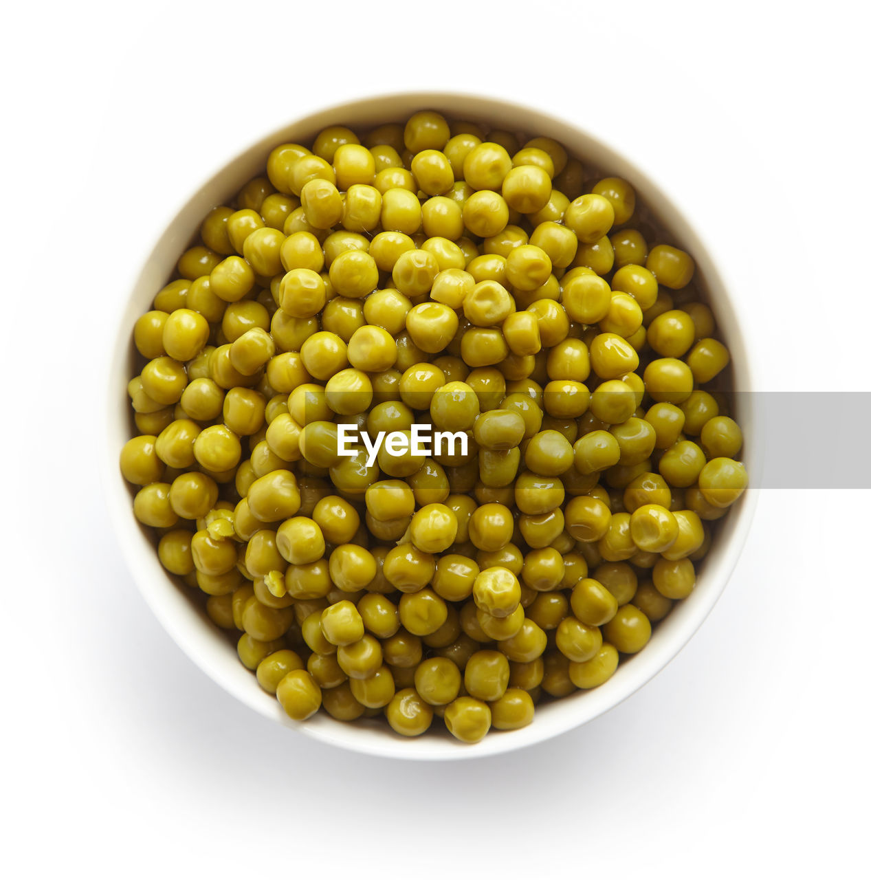 Bowl of green canned peas isolated on white background, top view