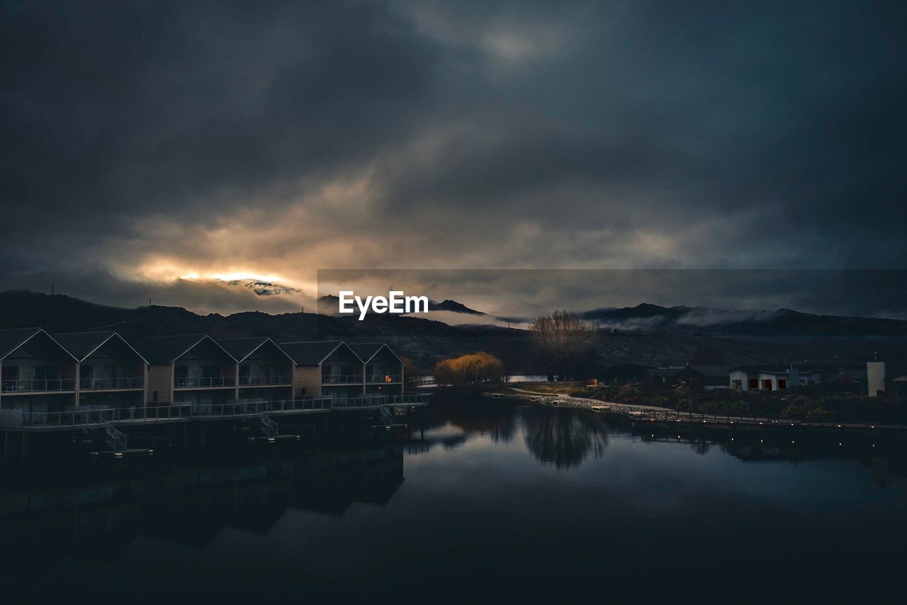 SCENIC VIEW OF LAKE BY BUILDINGS AGAINST SKY