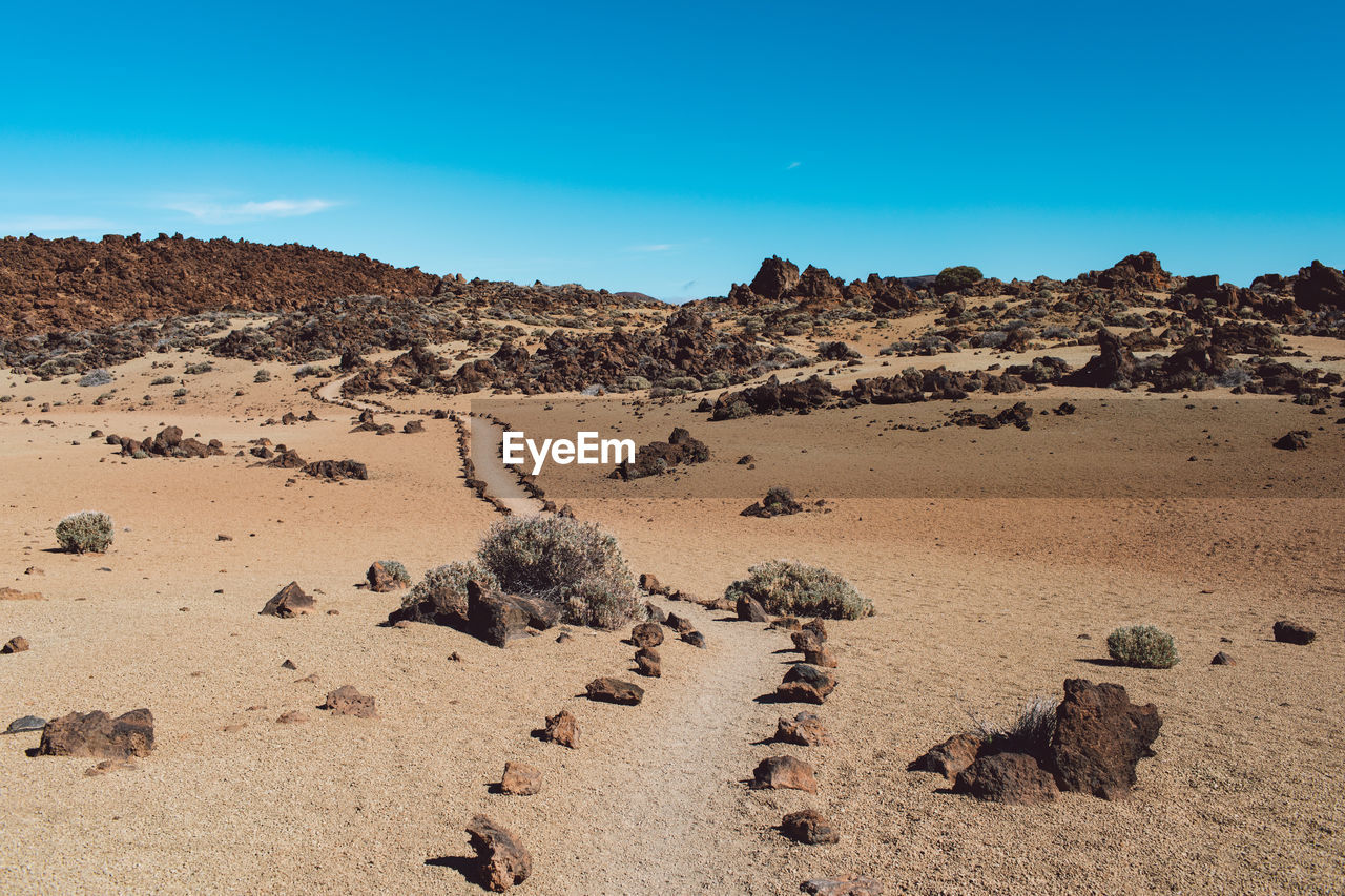 Scenic view of rock formations in desert against blue sky