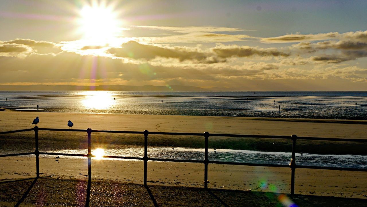 SCENIC VIEW OF BEACH AGAINST SKY AT SUNSET