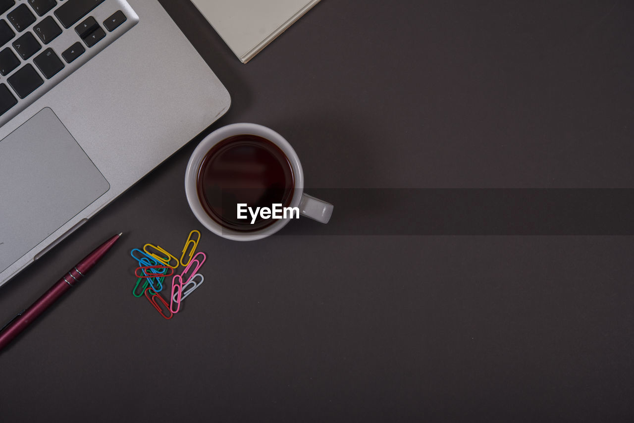 HIGH ANGLE VIEW OF COFFEE CUP ON TABLE AT HOME