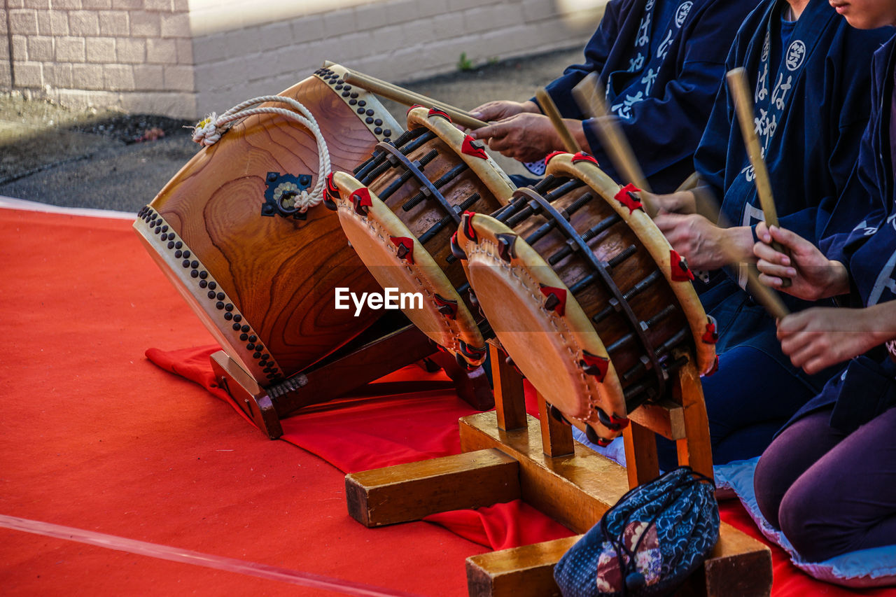 Midsection of people playing musical instruments outdoors