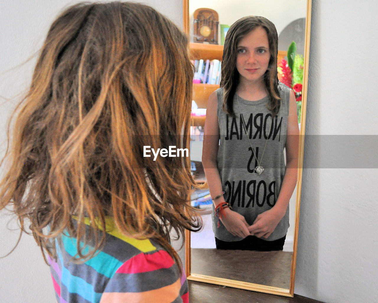 GIRL STANDING IN FRONT OF A SMILING WHILE HOLDING CAMERA