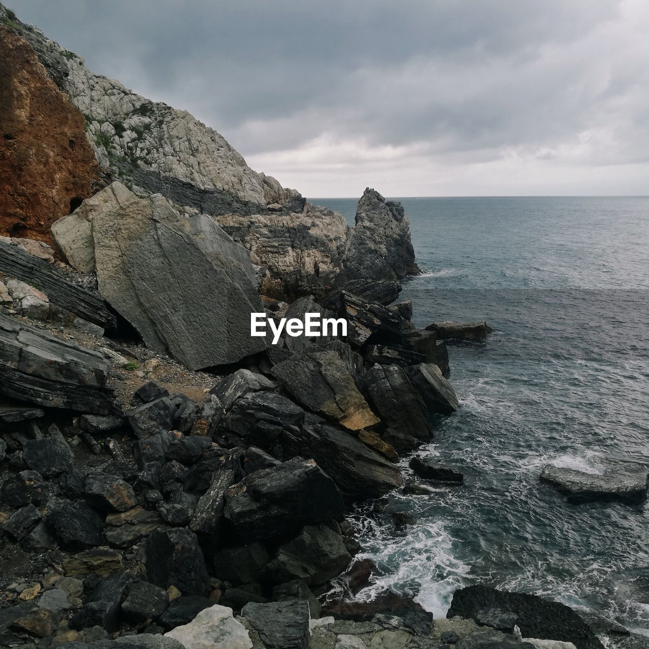 Rock formation in sea against sky