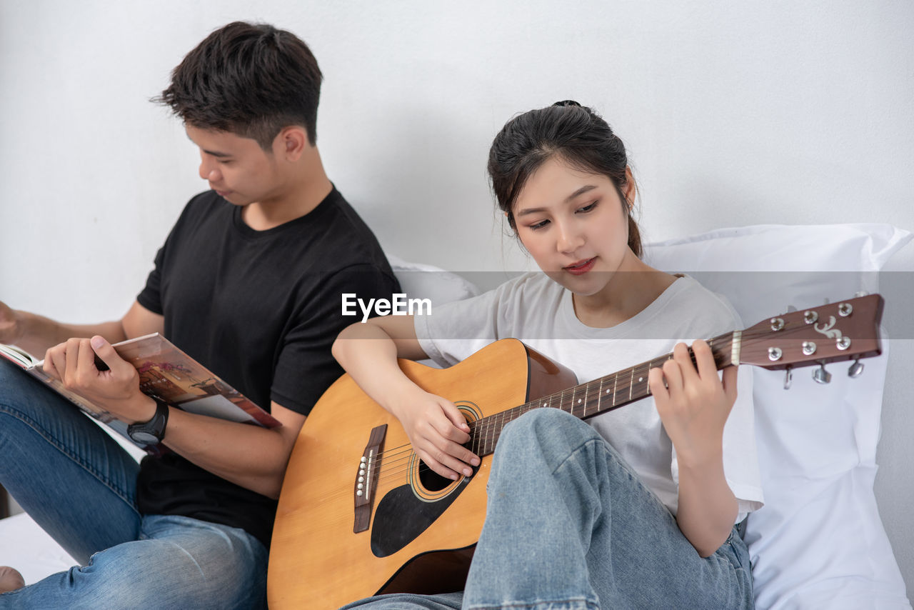 YOUNG MAN SITTING ON GUITAR