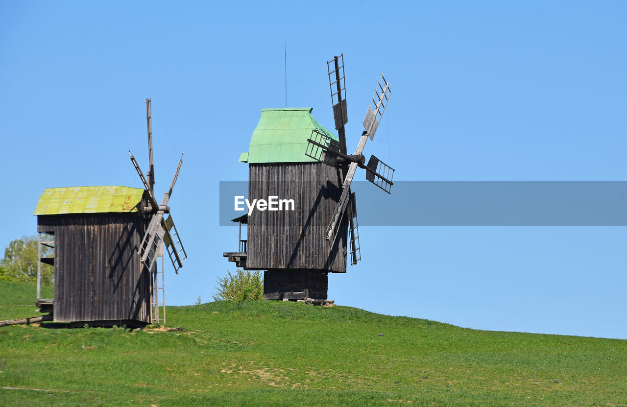 WINDMILLS ON GRASSY LANDSCAPE