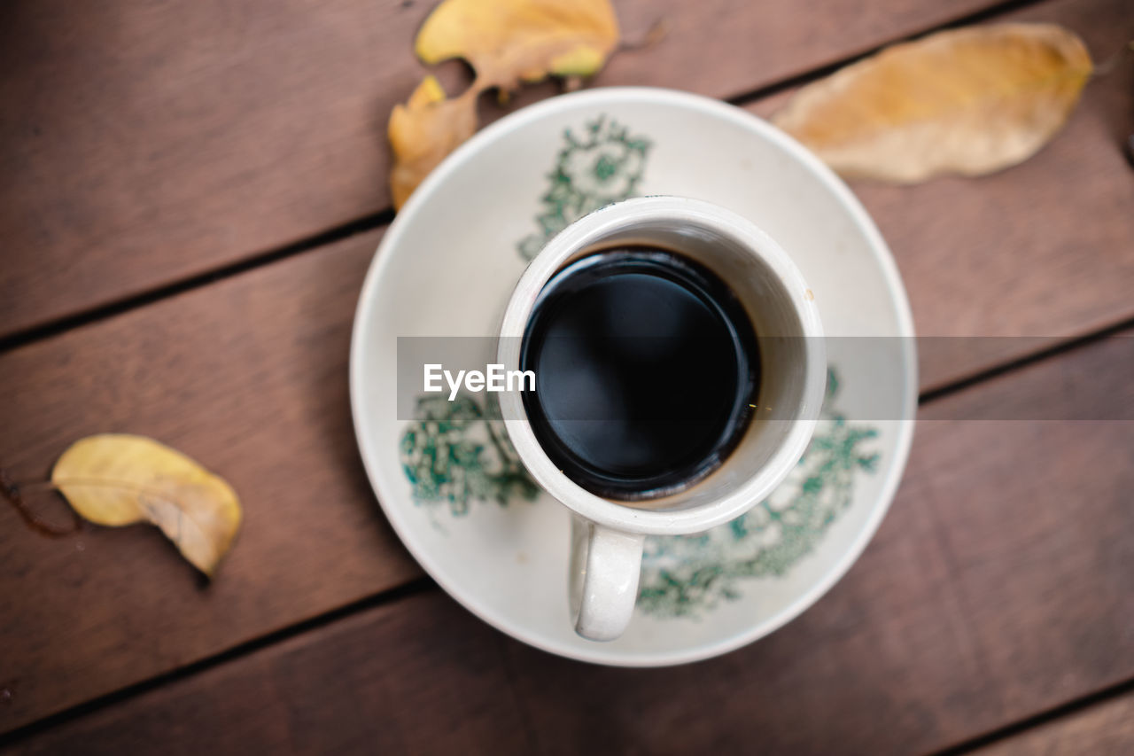 High angle view of coffee cup on wooden table