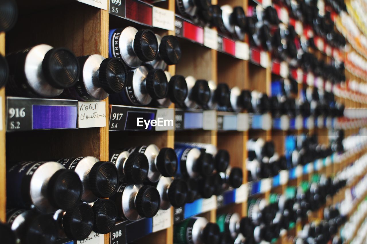 Close-up of bottles in shelves at shop for sale