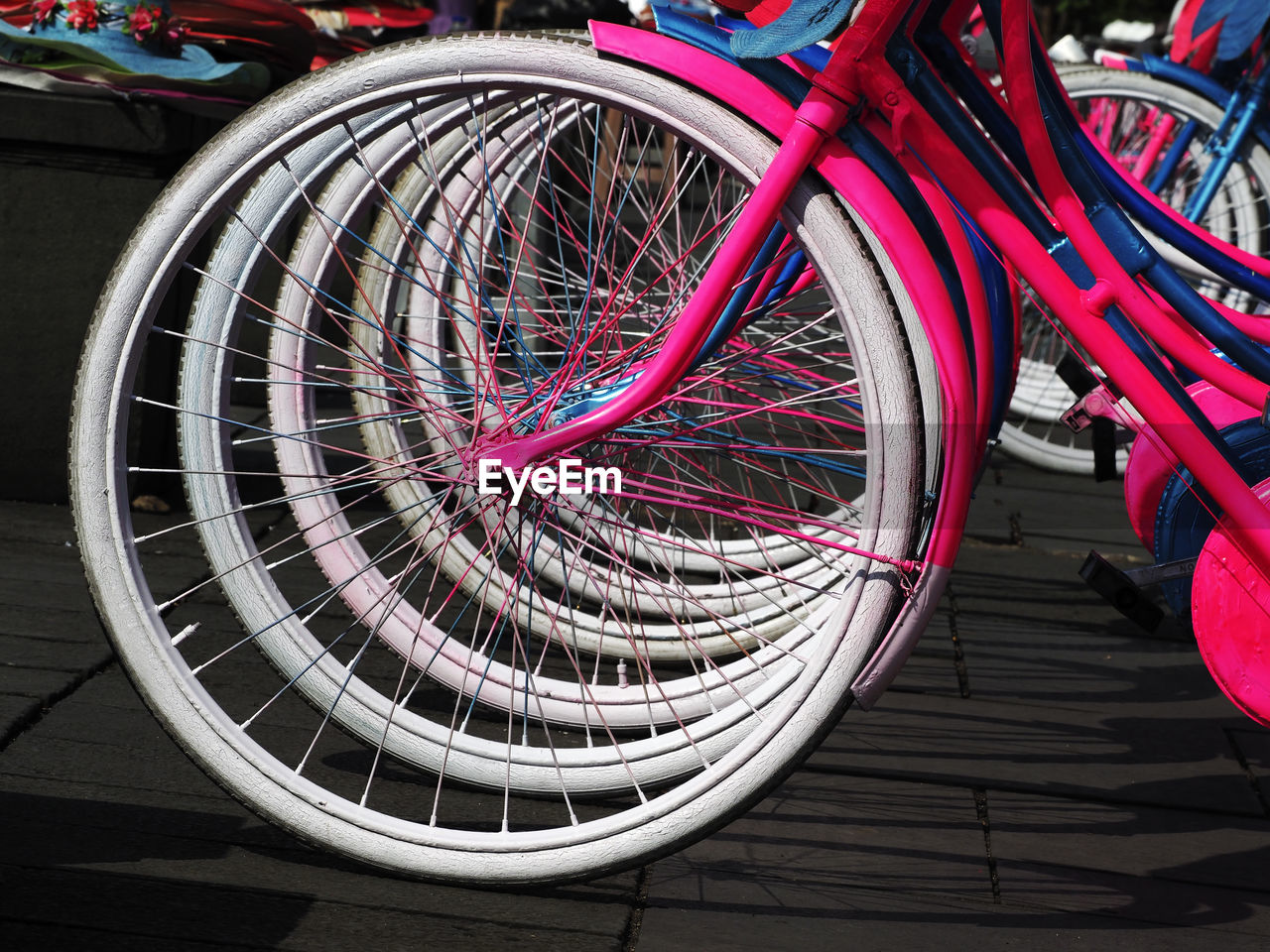 CLOSE-UP OF BICYCLE WHEEL BY RAILING