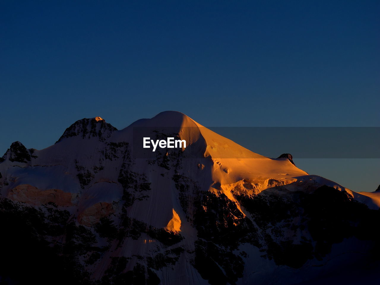 Scenic view of mountains against clear sky at sunset