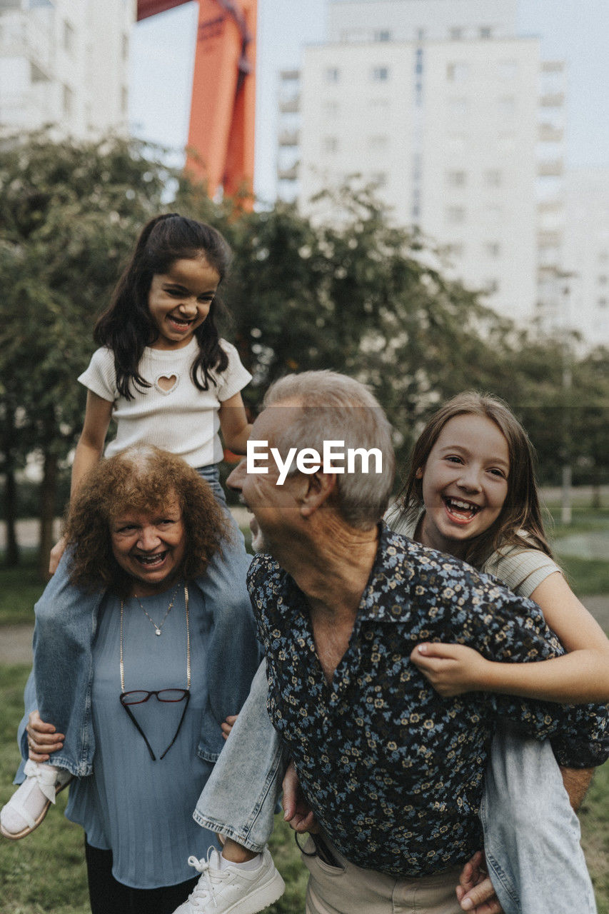 Playful grandparents and grandchildren enjoying at park