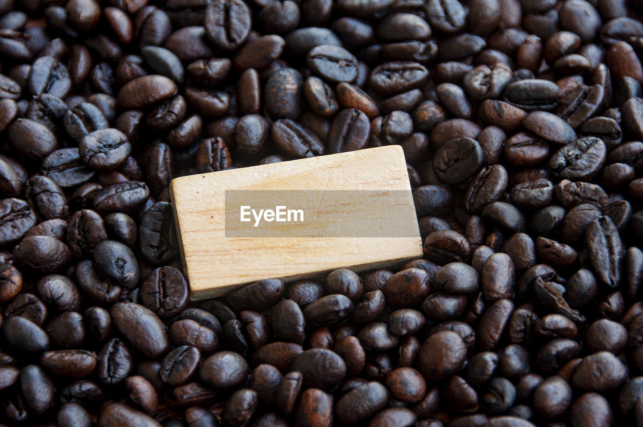 Blank wooden block surrounded by coffee bean. copy space