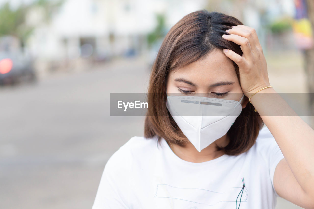 Beautiful woman wearing pollution mask on street