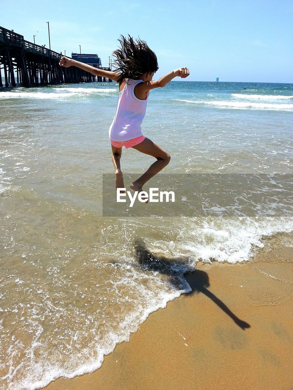 Full length of girl jumping at beach