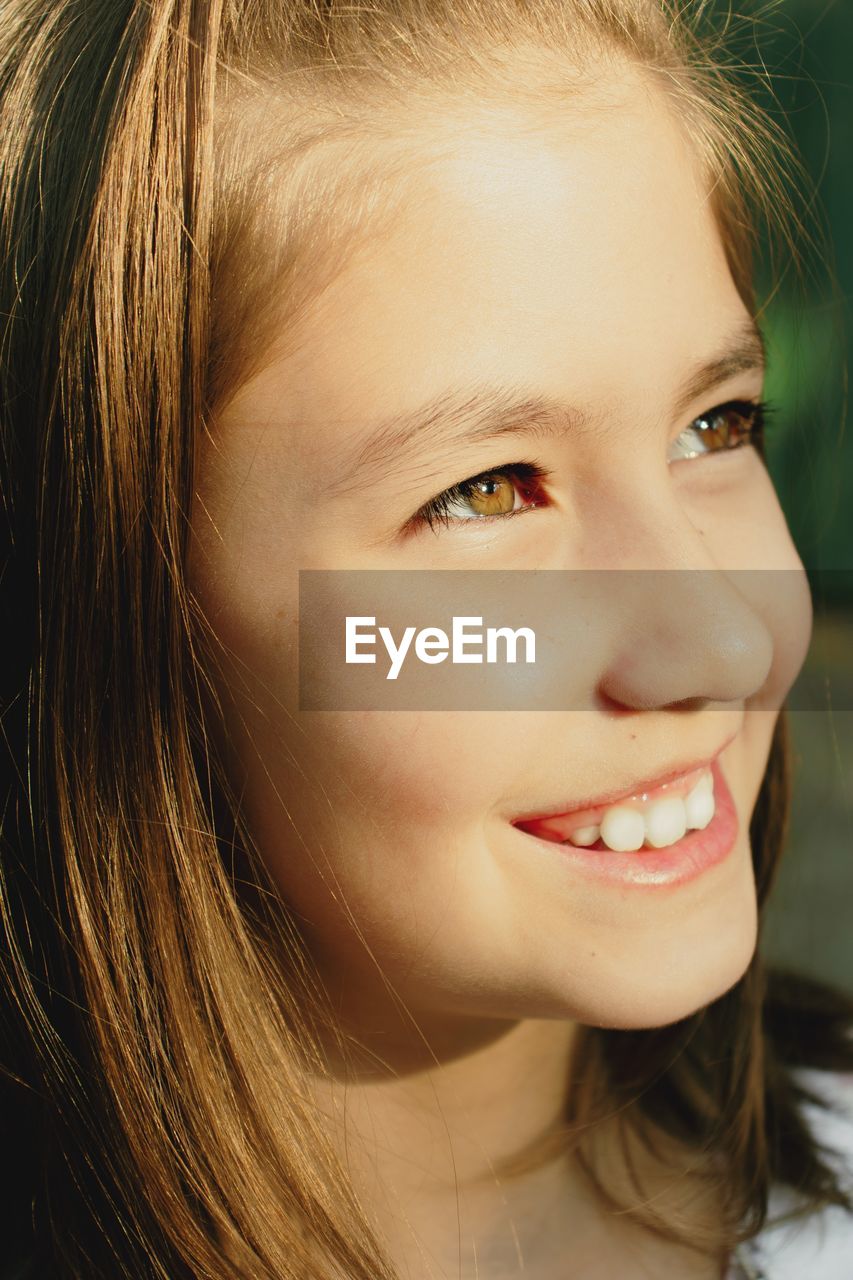 Close-up of smiling girl looking away