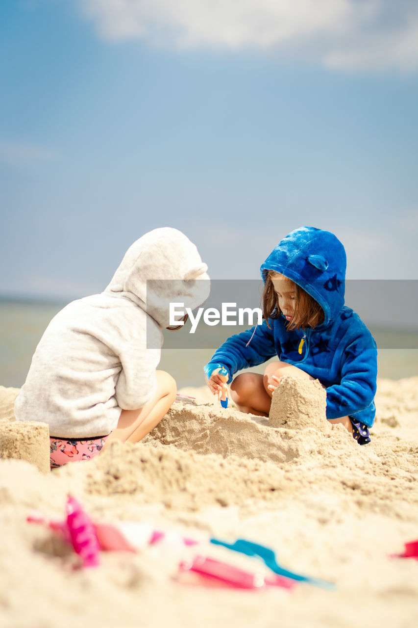 REAR VIEW OF CHILDREN ON BEACH