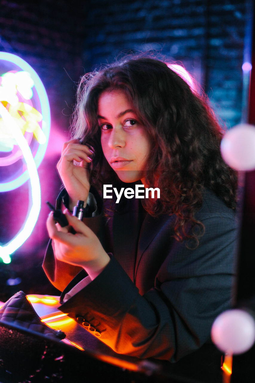 Portrait of young woman while sitting at restaurant