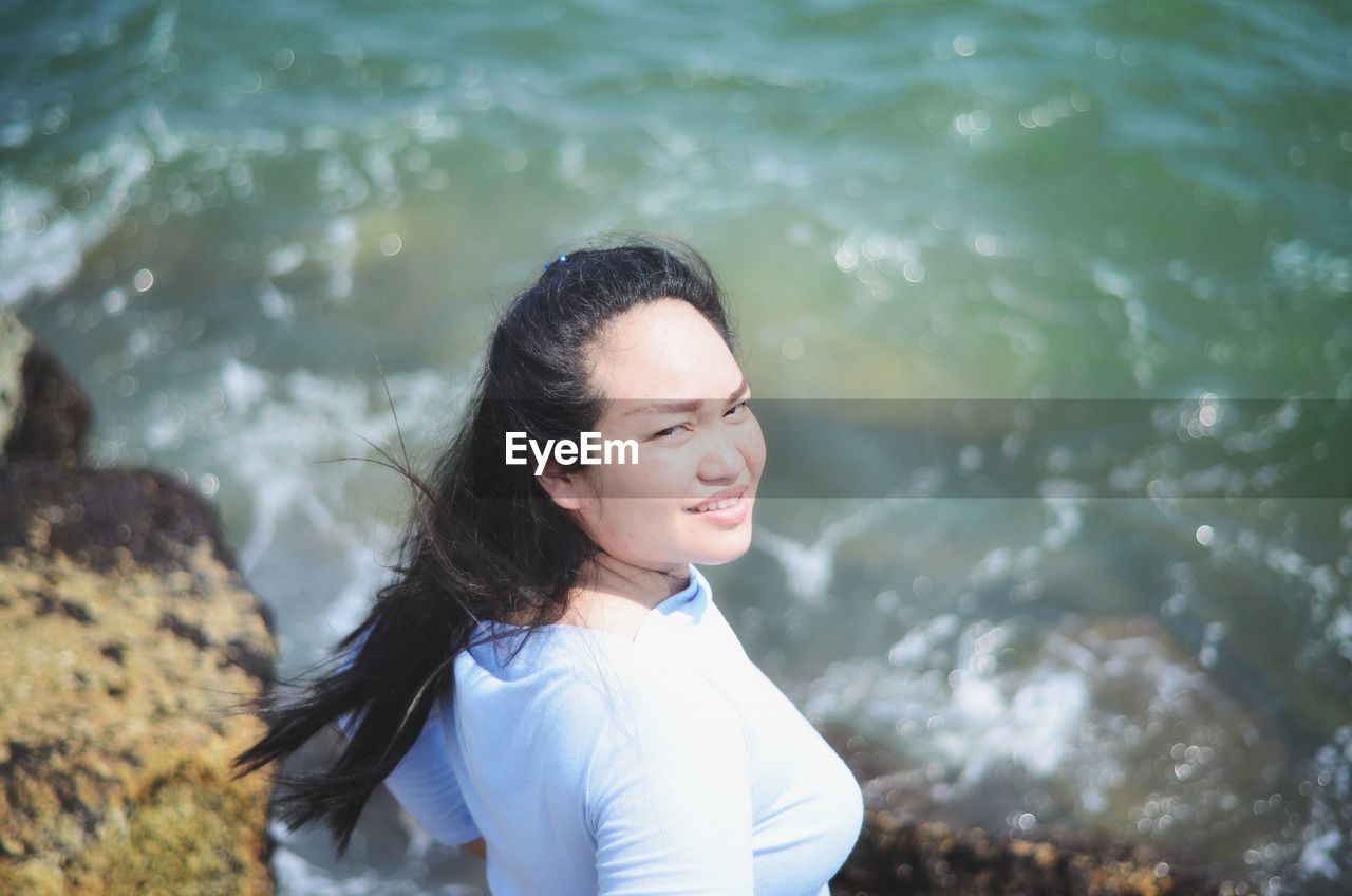 Portrait of a smiling young woman in water