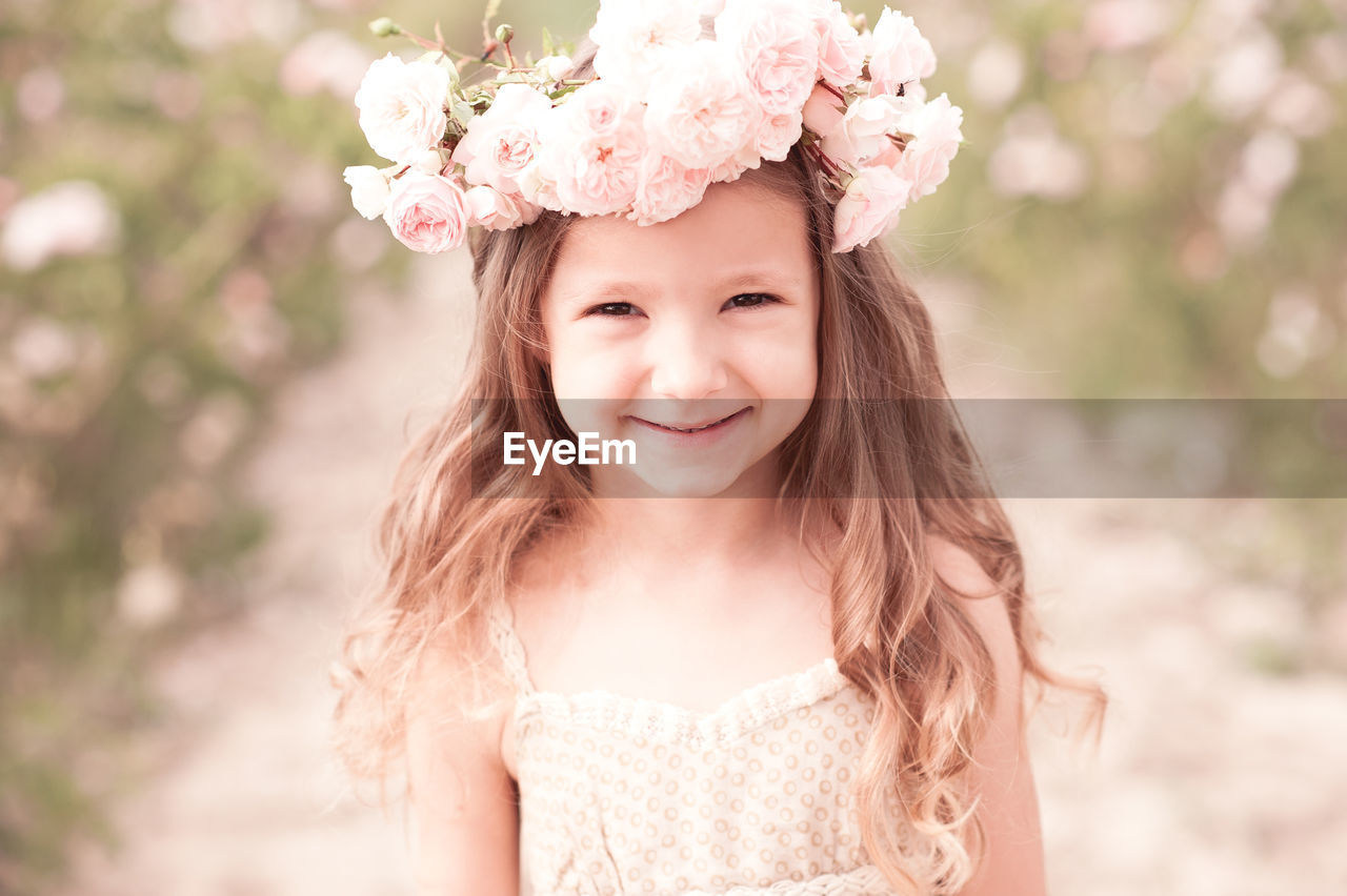 Portrait of cute girl wearing wreath at farm