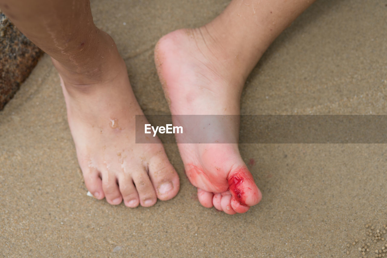 LOW SECTION OF CHILD ON SAND