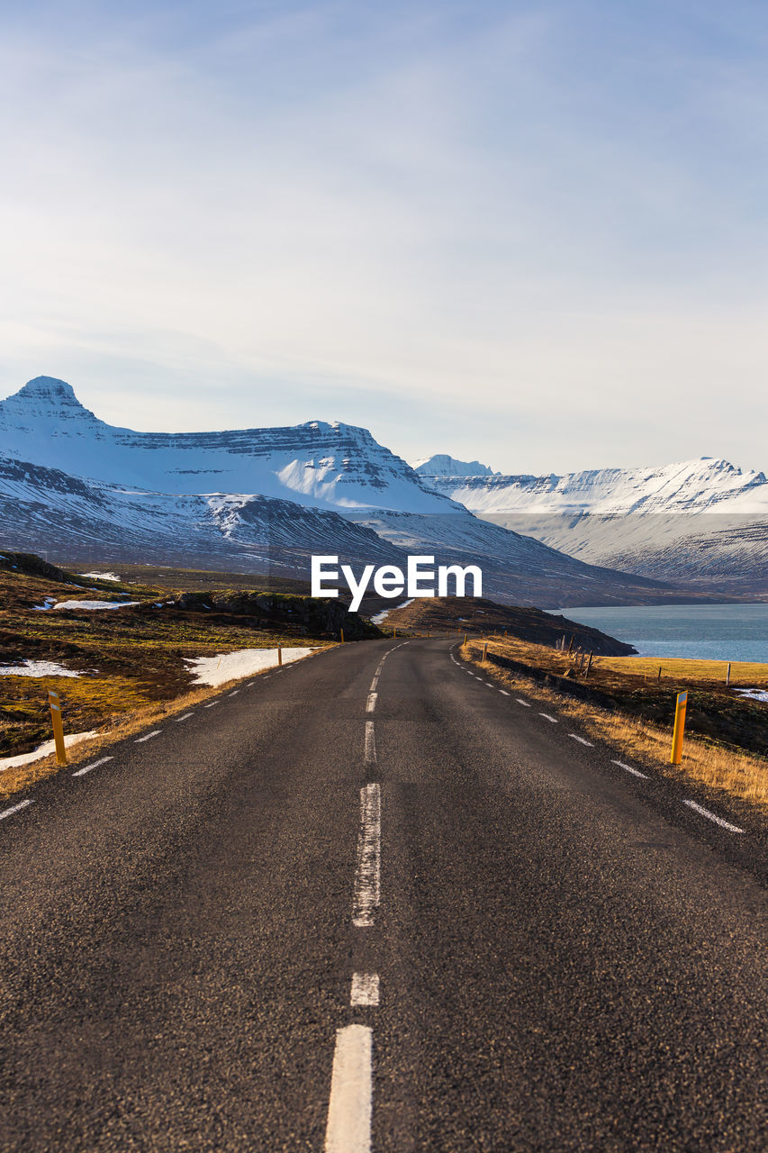 Road leading towards mountains against sky