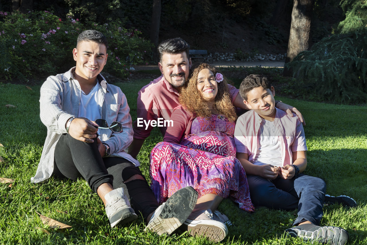 Portrait of happy family sitting on grass