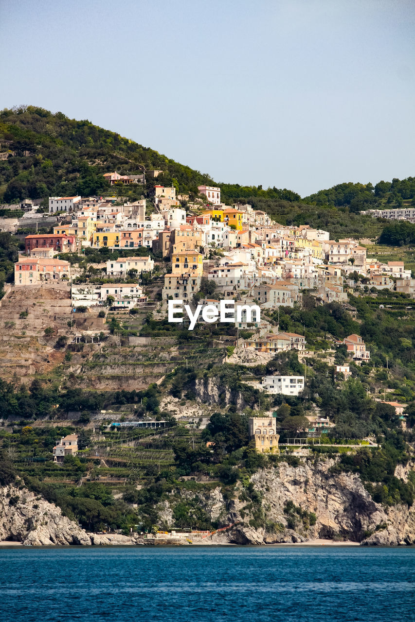 AERIAL VIEW OF TOWNSCAPE BY SEA AGAINST SKY