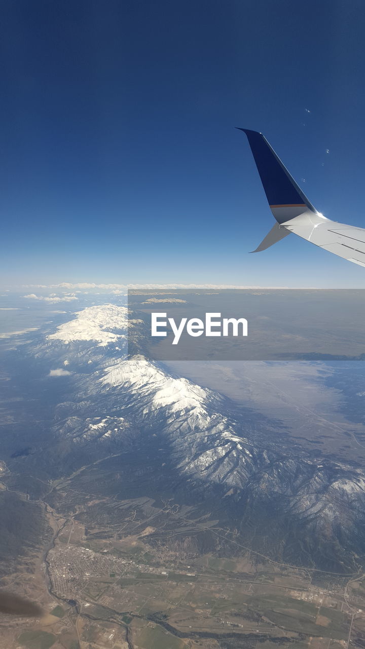 AIRPLANE WING OVER SEA AGAINST SKY