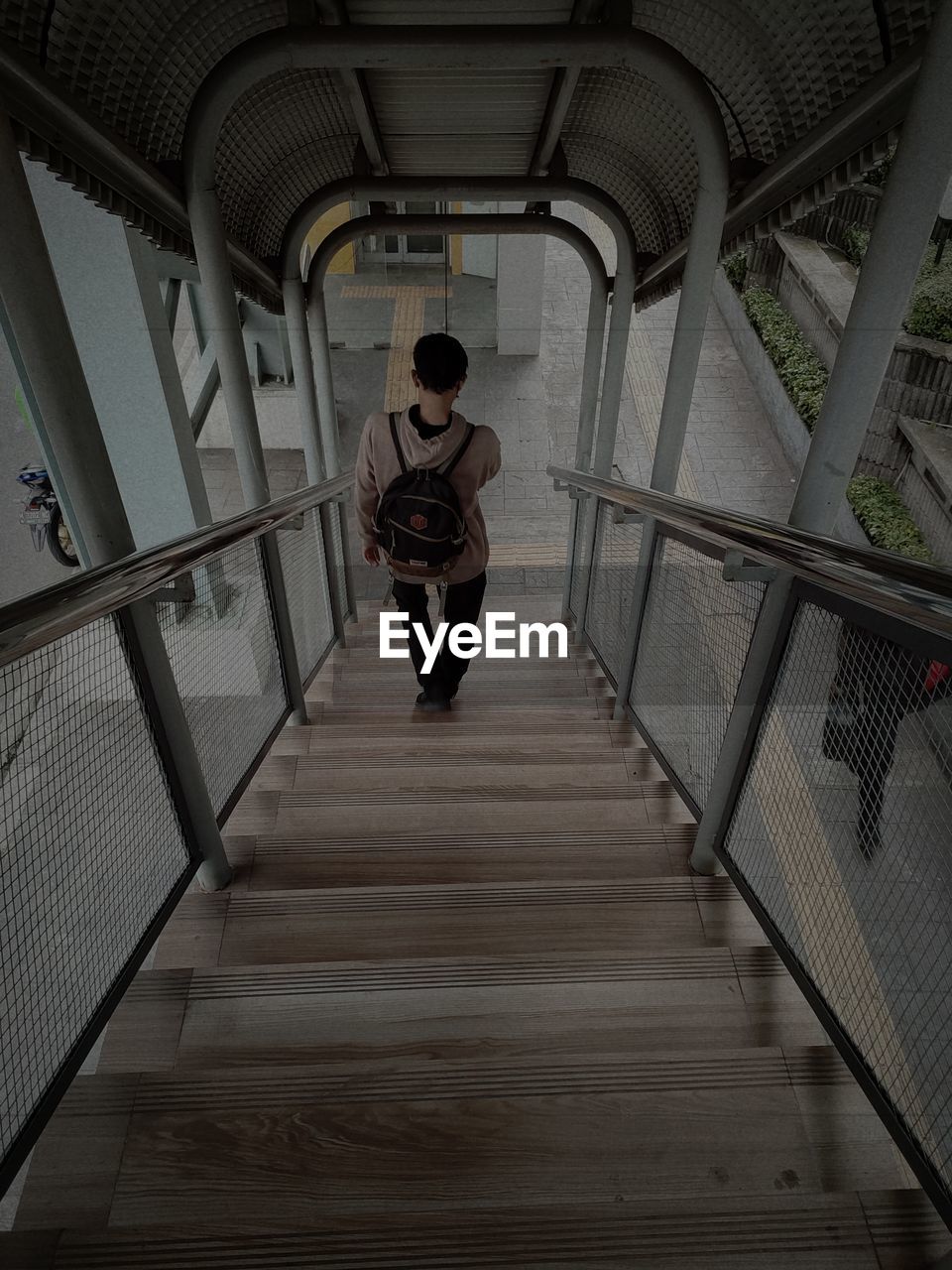 Rear view of woman walking in tunnel