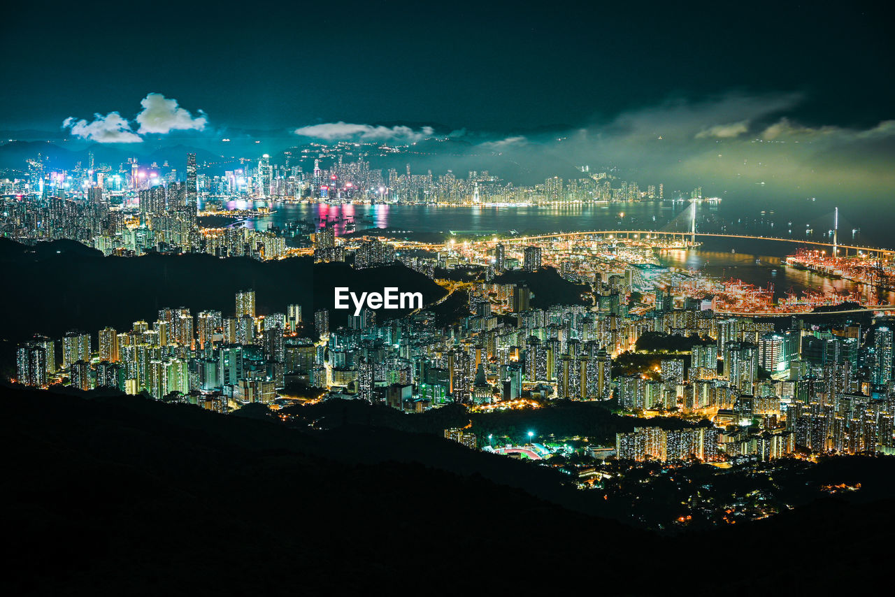 Illuminated cityscape against sky at night