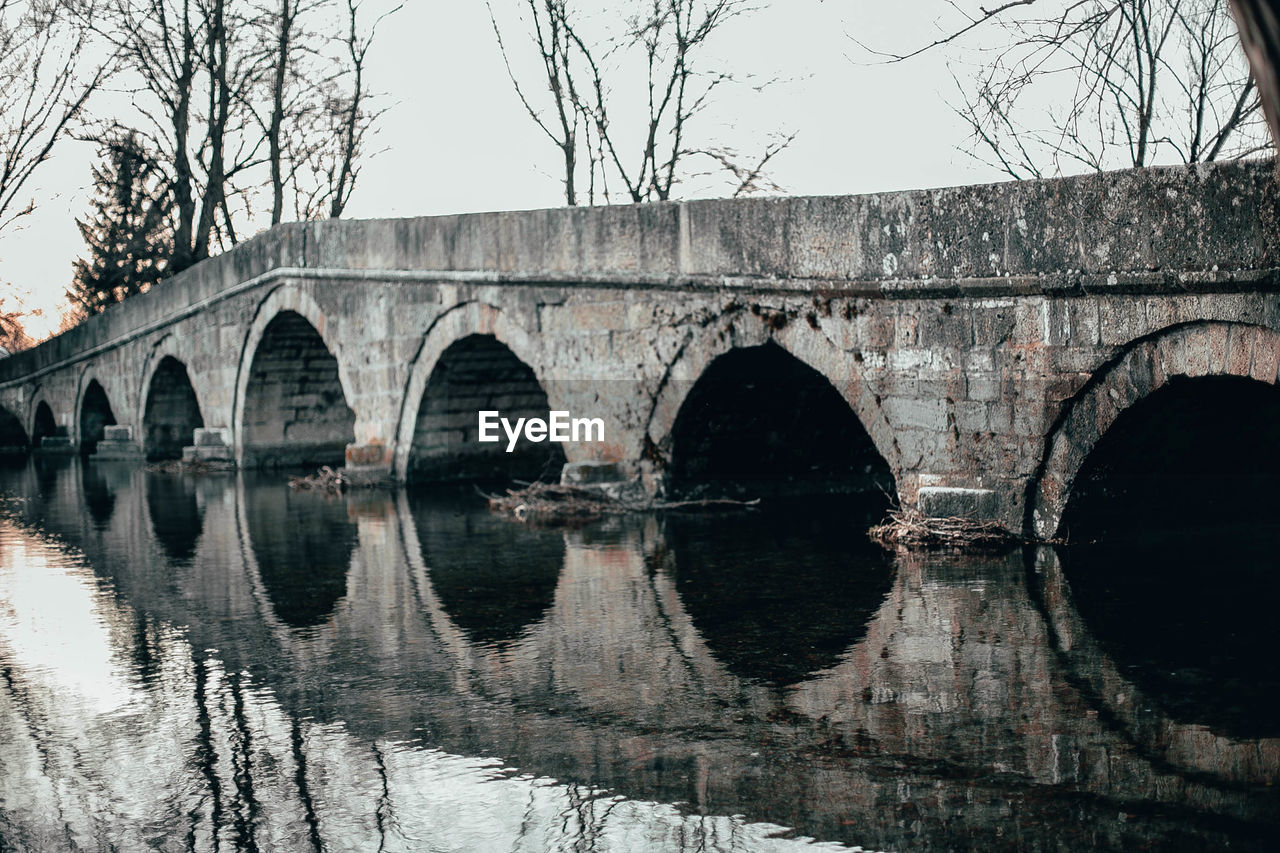 Arch bridge over lake against sky