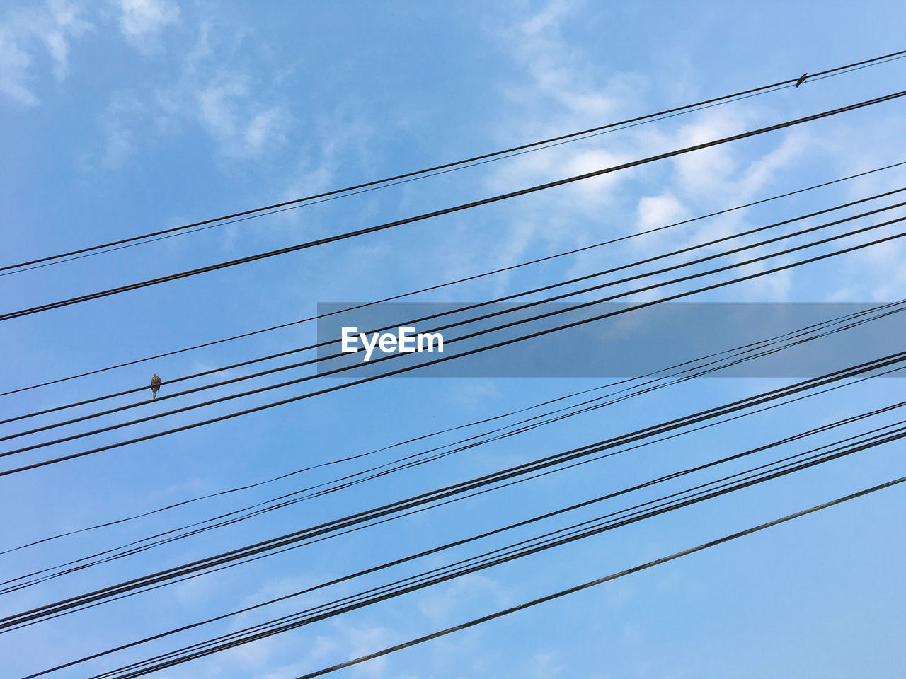 Low angle view of electricity pylon against blue sky